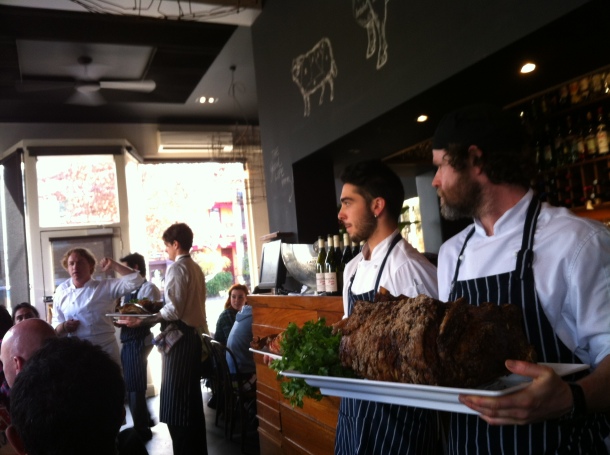 Adrian Richardson with his kitchen team, roasted animals in hand.
